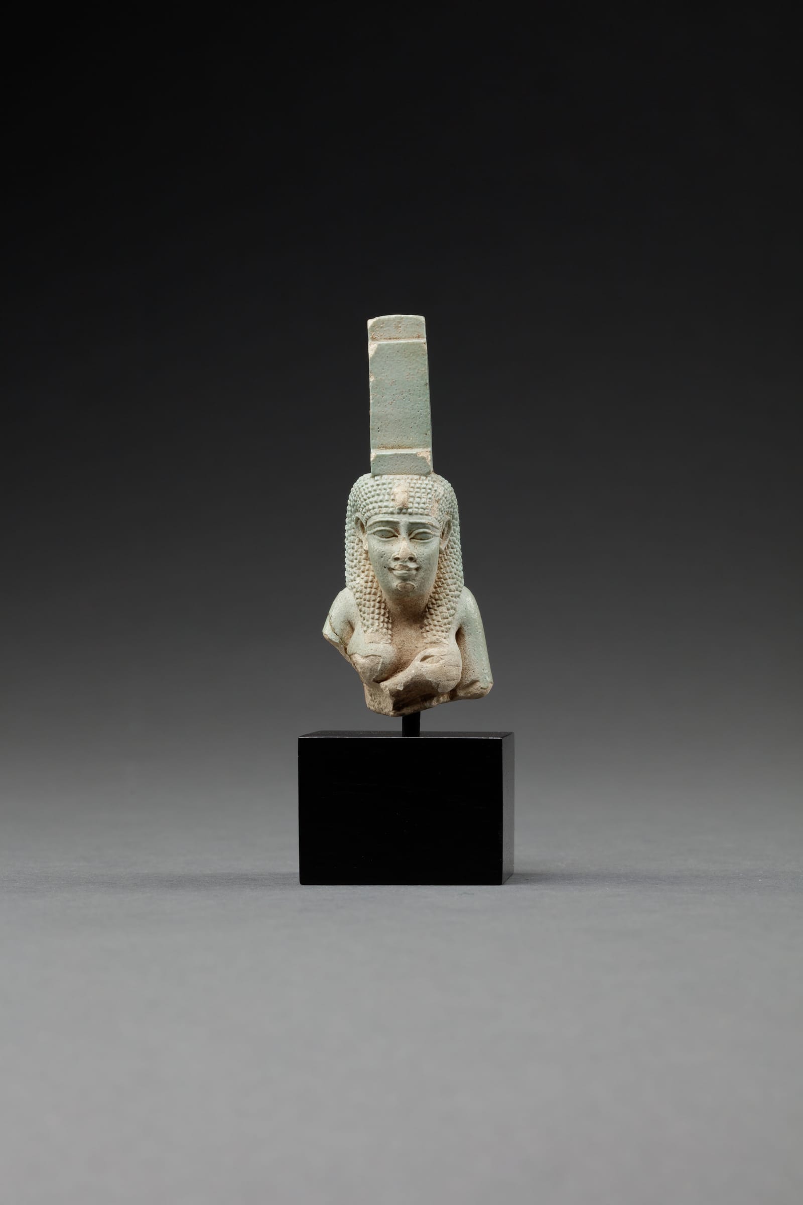 Upper part of a figure of Isis nursing Horus